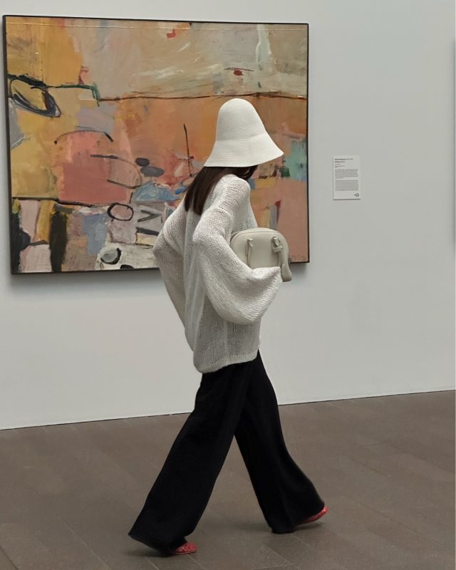 The Garment Literno Sweater Cream, The Row India 10.00 Bag in Leather, The Row Mara fishnet PVC ballet flats and Toteme Paper straw hat worn by Şirin Haban | Şirin Haban Outfits and Style