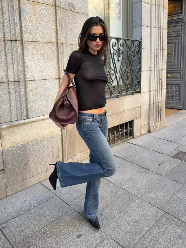 Khaite Silk Crew Neck T-Shirt, ABRAND 00 Andy Super Low Kick Flare Jeans, The Row Margaux 17 leather bag and SAINT LAURENT Ashley leather ankle boots worn by Ilirida Krasniqi | Ilirida Krasniqi Outfits and Style