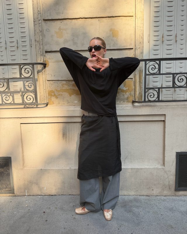 Christian Louboutin Cassiasticina Ballet Flat, Ray-Ban RB4068 Sunglasses, DUNST Black See-Through Layering Midi Skirt, COS RELAXED TWILL WIDE-LEG PANTS and COS RELAXED LONG-SLEEVED MOCK-NECK T-SHIRT worn by Sina Anjulie | Sina Anjulie Outfits and Style