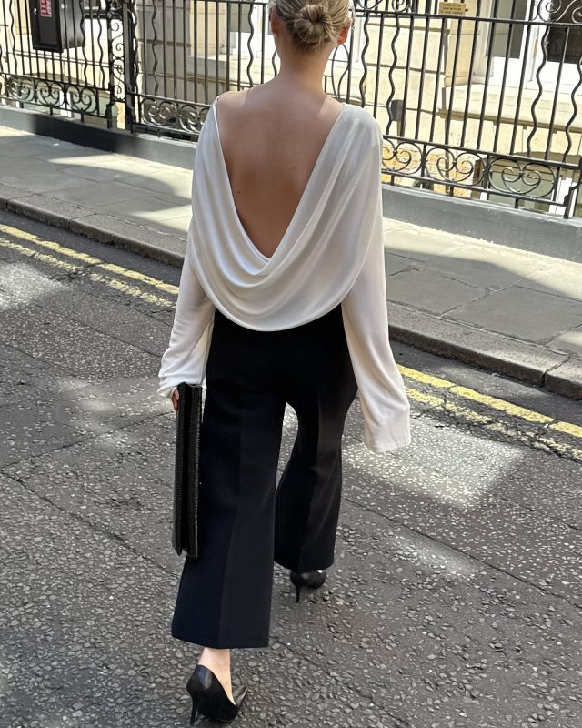 Jacquemus Croisière draped open-back crêpe jersey top, Soeur Black crocodile-embossed leather clutch bag, Saint Laurent Anne-Marie 75 leather pumps and Khaite Walter Crop Flare Pants worn by Victoria | Victoria Outfits and Style