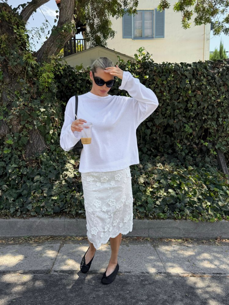 DISSH Sloane White Long Sleeve Crew Knit Top, The Garment Fleur Slip Skirt, H&M Round Sunglasses, THE ROW Fay Flat Two worn by Elsa Hosk.