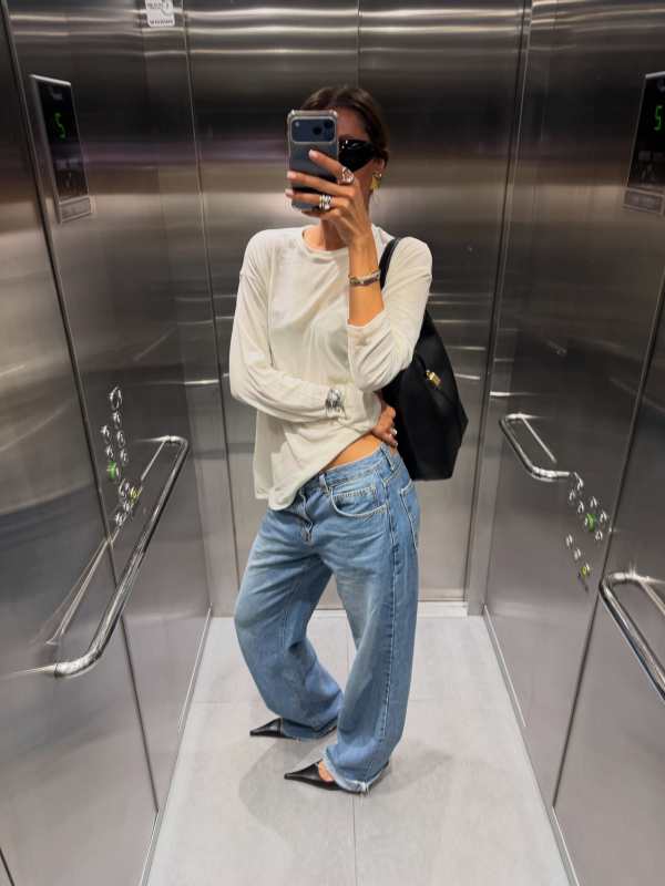 WEEKDAY LONG-SLEEVED BOXY COTTON T-SHIRT, DeMellier The Siena Bucket, The Frankie Shop Dalston Jeans - Medium Wash and Saint Laurent SL 914 worn by Virginie Martin